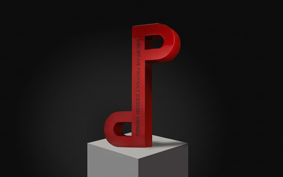 Trofeo dell’European Product Design Award in metallo spazzolato rosso su un piedistallo, con un occhiello a ciascuna estremità di una sbarra verticale
